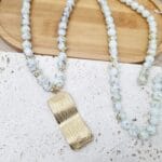 Μακρύ κολιέ με ατσάλινο ανάγλυφο στοιχείο και γυάλινες χάντρες